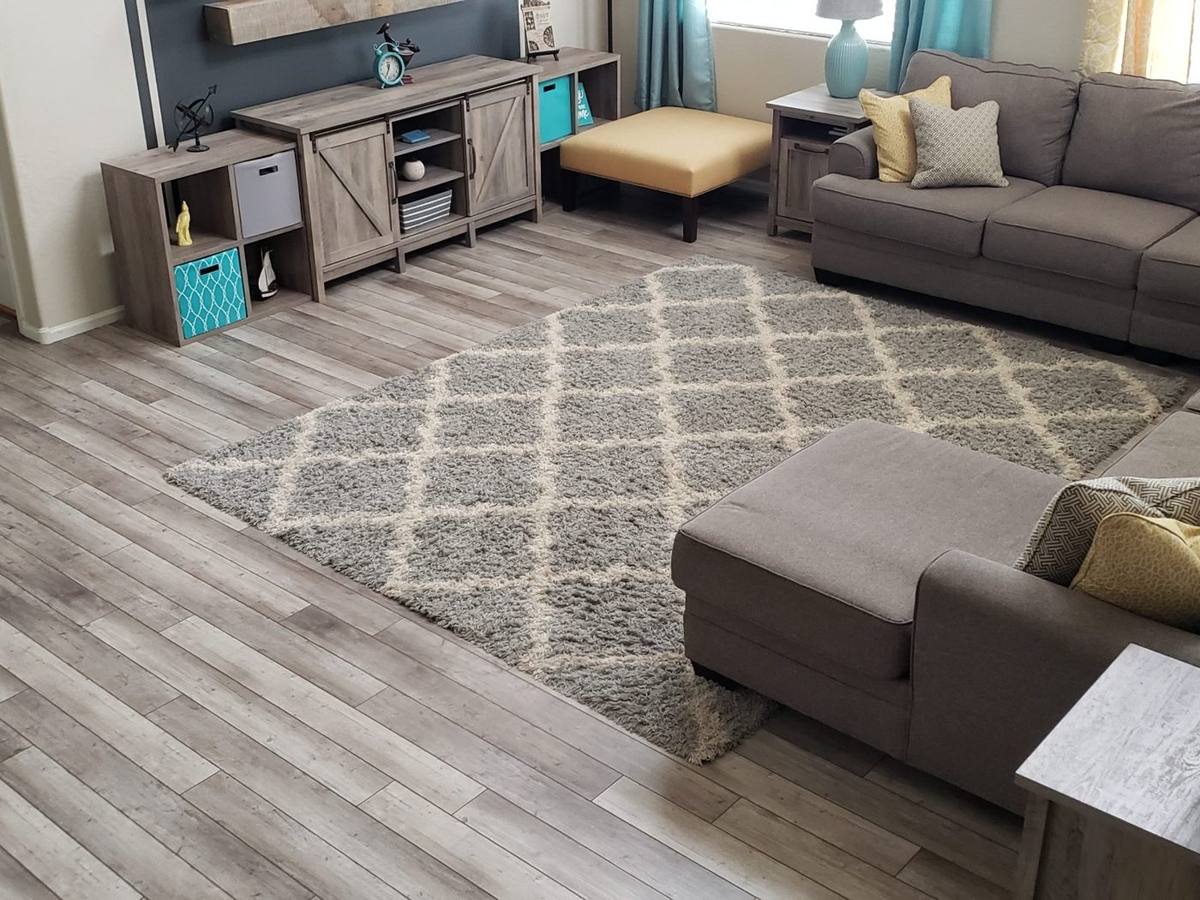 Gray wood-look luxury vinyl plank flooring installed in a fully furnished modern living room